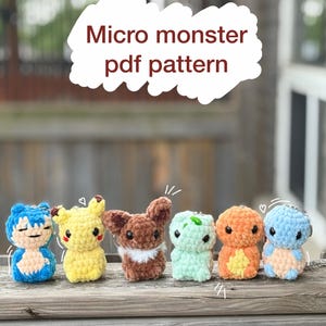 May include: Six small crocheted plush figures arranged in a row, featuring various colours including blue, yellow, brown, light green, and orange. The text 'Micro monster pdf pattern' is displayed in dark red letters above the figures.