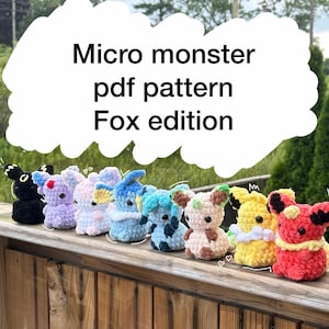 May include: A collection of eight small, crocheted plush figures in various colours including black, purple, light pink, blue, teal, brown, yellow, and red. The text "Micro monster pdf pattern Fox edition" is displayed above the figures.