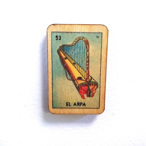 May include: A wooden card with a colorful illustration of a harp. The card is numbered 53 and the text "EL ARPA" is printed below the image.