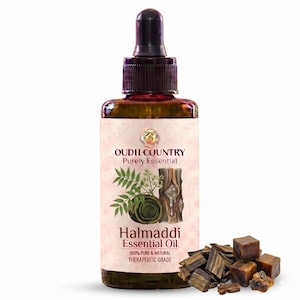 Könnte beinhalten: Eine dunkelbernsteinfarbene Glasflasche mit schwarzem Tropfverschluss, die Halmaddi ätherisches Öl enthält. Das Etikett zeigt den Text OUDH COUNTRY Purely Essential, Halmaddi Essential Oil, 100% PURE & NATURAL THERAPEUTIC GRADE sowie Illustrationen von Blättern und harzigem Holz. Kleine braune Harzstücke liegen neben der Flasche.
