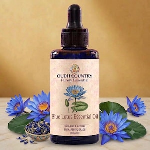 May include: A dark blue glass bottle with a black dropper cap containing Blue Lotus Essential Oil. The label features the text OUDH COUNTRY Purely Essential, Blue Lotus Essential Oil, 100% PURE & NATURAL THERAPEUTIC GRADE ORGANIC, and a blue lotus flower illustration.