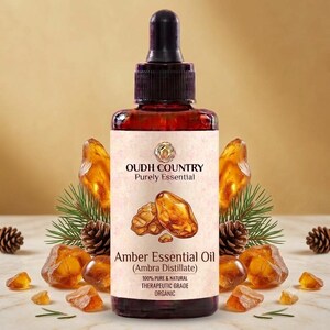 May include: A dark amber glass bottle with a black dropper cap containing Amber Essential Oil. The label features the text OUDH COUNTRY Purely Essential, Amber Essential Oil (Ambra Distillate), 100% PURE & NATURAL THERAPEUTIC GRADE ORGANIC.
