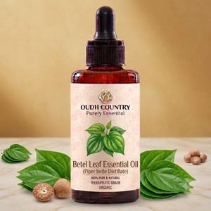 Peut inclure: Un flacon en verre ambré foncé avec un bouchon compte-gouttes noir contenant de l'huile essentielle de feuille de bétel. L'étiquette porte le texte OUDH COUNTRY Purely Essential, une illustration de feuilles de bétel vertes et le texte Betel Leaf Essential Oil.