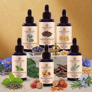 Könnte beinhalten: Sechs dunkelblaue Glastropfflaschen mit ätherischen Ölen von Oudh Country, beschriftet mit Blue Lotus, Oudh, Frankincense, Patchouli, Mace und Rosemary. Jede 10ml-Flasche zeigt eine botanische Illustration und den Hinweis 100% rein therapeutisch.