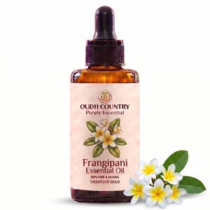 May include: An amber glass dropper bottle of Oudh Country Purely Essential Frangipani Essential Oil. The label features a white and yellow frangipani flower illustration with the text 100% PURE & NATURAL THERAPEUTIC GRADE. Fresh flowers sit nearby.