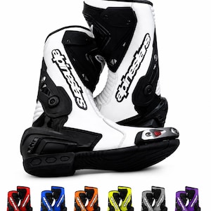 Puede incluir: Un par de botas de carreras de motociclismo blancas y negras con el logotipo de Alpinestars en el lateral, un deslizador de puntera metálico con un acento rojo y una suela negra texturizada. Debajo, seis pares adicionales se muestran en rojo, azul, naranja, amarillo, gris y morado.