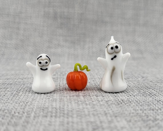 Tiny handcrafted glass ghost and pumpkin figurines that look like something from a quirky curiosity shop — genuinely delicate artisan work.