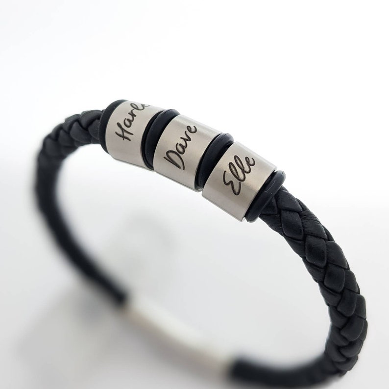 May include: Black leather bracelet with three silver beads engraved with the names "Harle", "Dave", and "Elle".