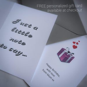 K&ouml;nnte beinhalten: Zwei wei&szlig;e Gru&szlig;karten. Eine Karte hat den Text "Just a little note to say..." in einer Schreibschrift. Die andere Karte hat eine lila Geschenkbox-Illustration mit roten Herzen und dem Text "Happy Birthday, with love from Mum xx."