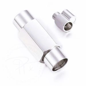K&ouml;nnte beinhalten: Ein Paar gl&auml;nzende, silberfarbene Metallverschl&uuml;sse. Einer ist gr&ouml;&szlig;er und sechseckig, mit zylindrischem Ende. Der andere ist kleiner und zylindrisch. Die Verschl&uuml;sse sind vor wei&szlig;em Hintergrund platziert.