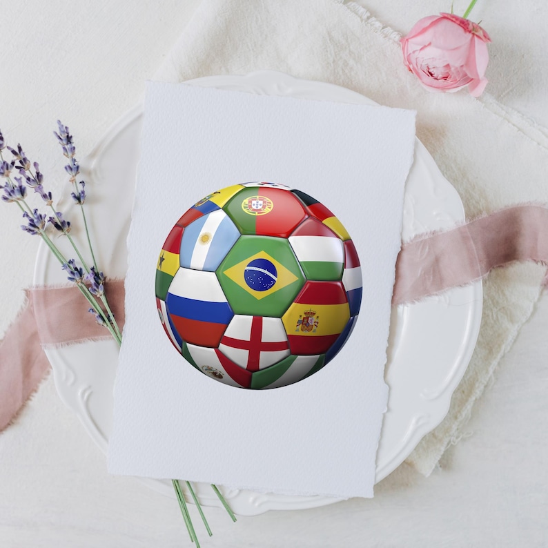 Puede incluir: Un bal&oacute;n de f&uacute;tbol con un patr&oacute;n multicolor compuesto por varias banderas nacionales, incluyendo Brasil, Argentina, Inglaterra, Espa&ntilde;a y Portugal, impreso en una tarjeta rectangular blanca con borde irregular, sobre un plato blanco.