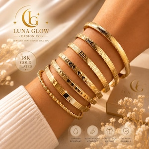 May include: A stack of seven gold-plated bracelets worn on an arm. The set includes a twisted rope bracelet, a flat band with star engravings, and several other bangles featuring various geometric, heart, and textured patterns in a bright gold finish.
