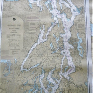 May include: A vintage nautical chart of Admiralty Inlet and Puget Sound, Washington. The chart is printed on a beige paper with blue and brown lines and text. The chart shows the coastline, islands, and waterways of the region. The title "Admiralty Inlet and Puget Sound" is printed in the upper left corner. The chart is dated 1948.