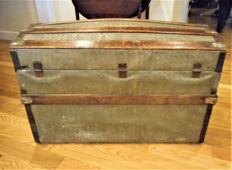 May include: A vintage green canvas and wood travel trunk with brass hardware and a wood frame.