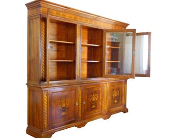 May include: A large, wooden cabinet with glass doors and shelves. The cabinet has a dark wood finish and intricate details. The doors are open, revealing the shelves inside.