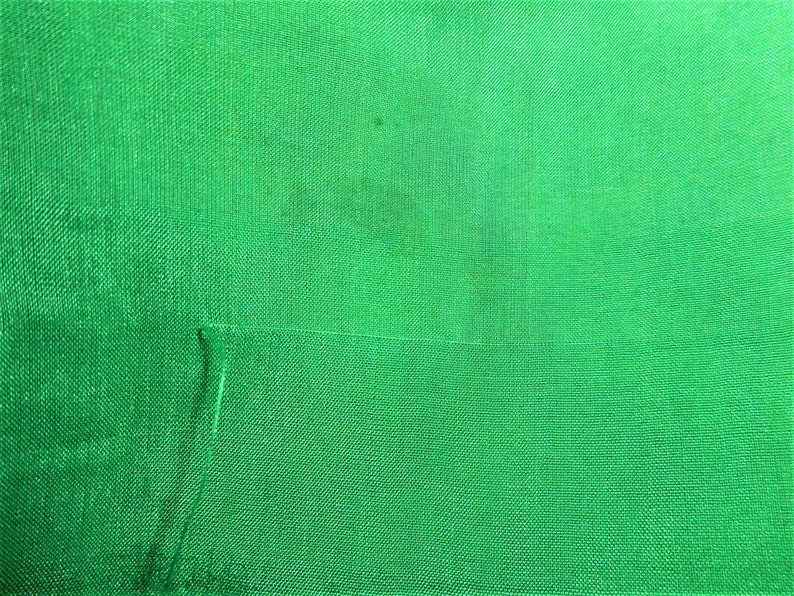 K&ouml;nnte beinhalten: Ein einfarbiger gr&uuml;ner Stoff mit einer dezenten gewebten Textur. Der Stoff hat einen leichten Glanz und ist glatt anzufassen.