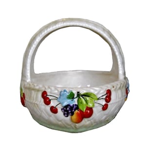 May include: White ceramic basket with a handle, decorated with painted cherries, grapes, and a pear.