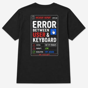 Peut inclure: Un t-shirt noir à manches courtes avec un motif blanc, rouge et bleu au dos. Le design ressemble à un rapport d'incident #PXP-404, avec le texte ERROR BETWEEN USER & KEYBOARD, le statut NOT MY PROBLEM, la priorité LOW et la résolution TRY AGAIN.