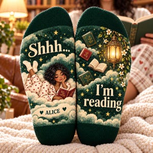 May include: A pair of dark green socks featuring a graphic of a person reading on clouds. The text reads Shhh... I'm reading and includes the name Alice. The design includes floating books, a glowing lantern, stars, and small red hearts.