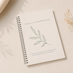 May include: A spiral-bound workbook with the title "Anxiety to Calm Workbook" and a botanical illustration. The cover is a light beige color, with text and a leaf design in a muted green. The workbook is designed to help with overthinking, stress, and emotional overwhelm.