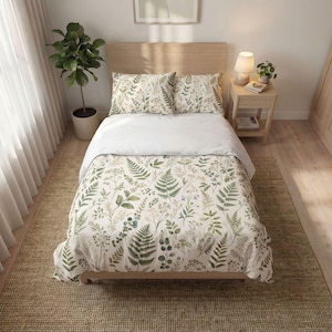 May include: A bed featuring a white duvet cover and two matching pillowcases, all decorated with a botanical print of green ferns and various wild plants. The bed has a light wood headboard and is positioned in a room with a light wood floor.