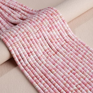 May include: Multiple strands of small, flat, circular beads in varying shades of pink and white. The beads are arranged in parallel rows, showcasing a smooth, disc-like shape with a consistent texture and a soft, variegated color palette.