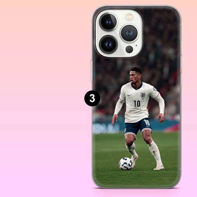 May include: A clear smartphone case featuring a printed image of a soccer player wearing a white jersey with the number 10, dark blue shorts, and white socks, dribbling a soccer ball on a green field with a blurred stadium background.