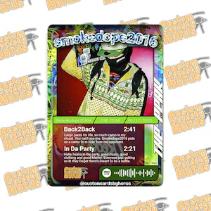 May include: A rectangular trading card featuring a digital illustration of a person in a patterned yellow jacket and black face mask. The card displays the text smokedope2016, The Peak, song titles Back2Back and In Da Party, and a Spotify code.