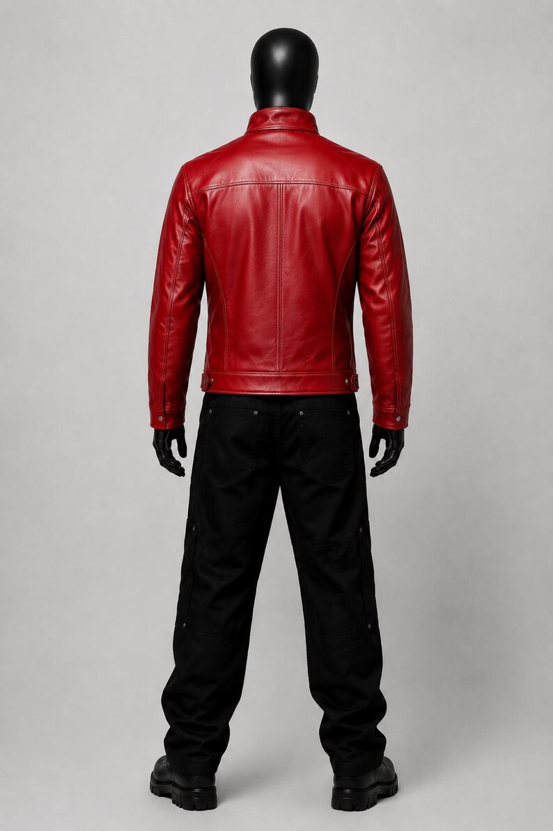 May include: A vibrant red leather jacket with a structured collar, long sleeves, and buttoned cuffs, paired with loose-fitting black trousers featuring side pockets and metallic rivets, displayed on a mannequin against a neutral gray background.