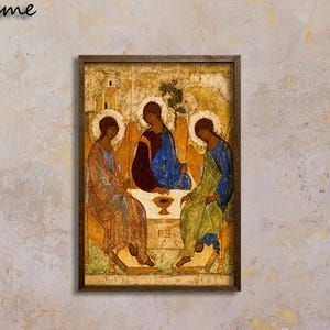 May include: A rectangular wall art print featuring the Rublev Trinity icon, depicting three figures seated around a table with a chalice, enclosed in a dark walnut frame. The artwork displays gold, blue, and green tones in a traditional style.