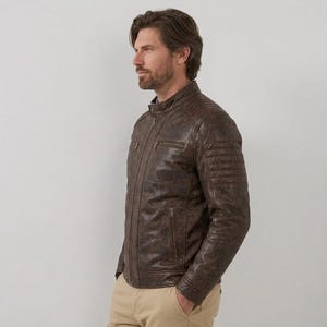 Men's brown leather jacket with quilted shoulder details and zipper pockets