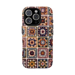 Op de afbeelding: Een smartphonehoesje met een herhalend rasterpatroon van kleurrijke gehaakte vierkantjes. Het ontwerp toont diverse bloemachtige motieven in tinten mosterdgeel, diepbordeaux, marineblauw, zachtroze en crème, gerangschikt in een gestructureerde lay-out.