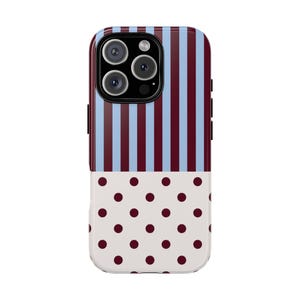 Op de afbeelding: Een smartphonehoesje met een verdeeld ontwerp. De bovenste helft toont verticale strepen in lichtblauw en donker kastanjebruin. De onderste helft heeft een witte achtergrond met een herhalend patroon van donker kastanjebruine stippen. De camera-uitsparing is zwart.