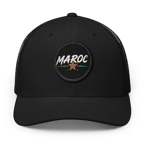 Peut inclure: Casquette de camionneur noire avec une visière incurvée et un dos en filet. L'avant présente un écusson circulaire avec le mot "MAROC" en blanc, avec un motif d'étoile verte et rouge.