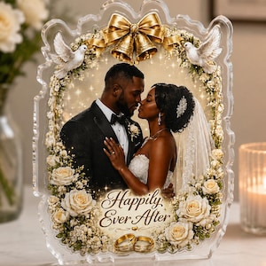 May include: A clear acrylic plaque featuring a wedding photograph of a couple, framed by white roses, baby's breath, two white doves, and gold bells. The text "Happily Ever After" is printed at the bottom above two gold wedding rings.