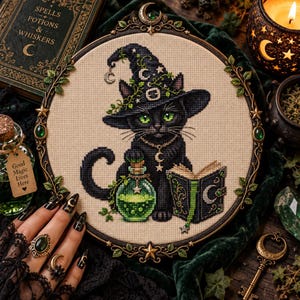 May include: A circular cross-stitch embroidery featuring a black cat wearing a witch hat adorned with vines and a crescent moon. The cat sits beside a green potion bottle and an open book, all framed in an ornate, dark metal hoop with leaf accents.
