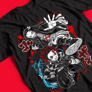 Op de afbeelding: Een zwart t-shirt met een grafische illustratie van twee anime-personages in actie. Het ene personage heeft lang donker haar en een bamboe mondkapje, terwijl de andere een zwaard hanteert met blauwe watereffecten. Rode Japanse tekst accentueert het ontwerp.