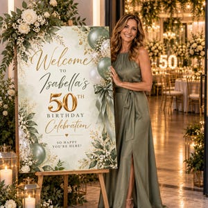 Op de afbeelding: Een rechthoekig welkomstbord voor een 50e verjaardag met saliegroene aquarelaccenten, gouden letters en bloemillustraties. De tekst luidt: Welcome to Isabella's 50th Birthday Celebration. So happy you're here!