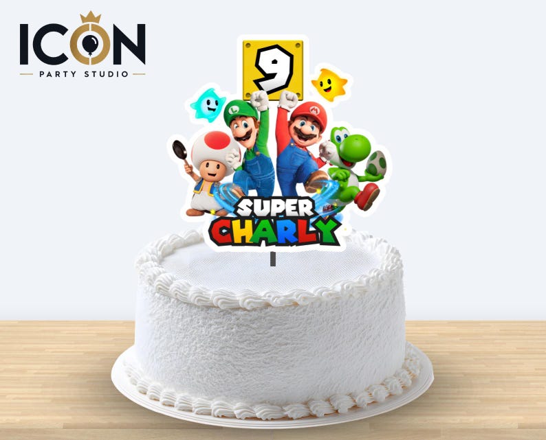 May include: A white frosted cake topped with a Super Mario themed cake topper featuring Mario, Luigi, Toad, and Yoshi. The topper includes a yellow block with the number 9 and the text Super Charly in colorful, bold, block-style lettering.