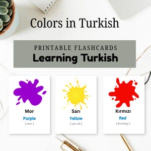 May include: Educational flashcards for learning Turkish colors. Three white cards display a purple, yellow, and red paint splatter graphic. Each card includes the Turkish word, English translation, and pronunciation guide. Text reads Colors in Turkish.