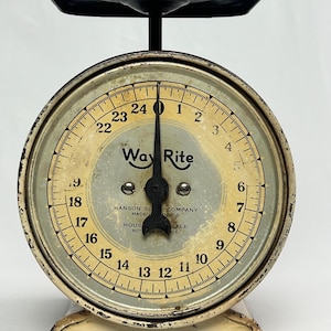 Puede incluir: Una báscula doméstica vintage Way Rite Hanson Scale Company con cuerpo de metal color crema y esfera redonda. La esfera presenta números negros del 1 al 24, una aguja negra y el texto Way Rite, Hanson Scale Company, Made in Chicago.