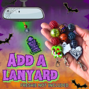 May include: Three beaded lanyards featuring Halloween-themed charms including a green hand, a white ghost, and a black heart with white skulls. The beads are red, green, orange, and black with spiderweb patterns and metallic finishes.