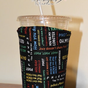 May include: A black fabric cup cozy with colorful text from the TV show "Friends" including "Pivot", "How You Doin'" and "Joey Doesn't Share Food".