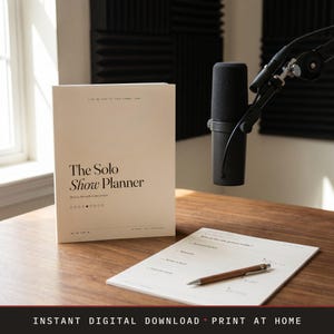 Puede incluir: Un cuaderno beige "The Solo Show Planner" con texto y un bloc de notas y bolígrafo a juego sobre un escritorio de madera. Un micrófono negro está posicionado a la derecha. El texto "Instant Digital Download • Print at Home" está en la parte inferior.