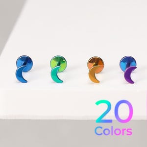 May include: Four crescent moon stud earrings with flat back posts, each featuring a distinct iridescent metallic finish in blue, green, orange, and purple. The text 20 Colors is displayed in the lower right corner of the image.
