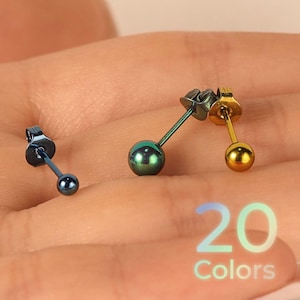 May include: Three stud earrings with spherical heads and metal posts. One earring is dark blue, one is iridescent green, and one is gold. The text 20 Colors is visible in the lower right corner, indicating a variety of available options.