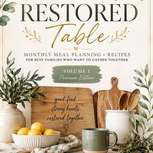 以下が含まれることがあります： 「RESTORED Table」というタイトルの料理本で、「MONTHLY MEAL PLANNING + RECIPES」というサブタイトルが付いています。表紙は、木製のまな板、レモン、セラミックマグカップを使った素朴なデザインです。この本はVolume 1、Premium Editionです。