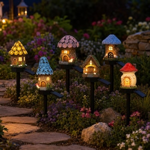 Puede incluir: Una colección de luces solares para jardín con forma de casas de hadas caprichosas. Cada casa presenta un diseño único con tejados coloridos y ventanas brillantes, ambientadas en un exuberante jardín con senderos de piedra y flores vibrantes. Las luces están en estacas negras.