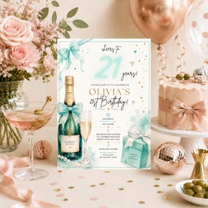 Könnte beinhalten: Eine Einladungskarte zum 21. Geburtstag mit einer Champagnerflasche mit türkisfarbener Schleife, einem Sektglas, einem Geschenk und dem Text cheers to 21 years, Olivia's 21st Birthday, Saturday August 25, 2027, at 6:00 PM, The Rooftop Lounge.
