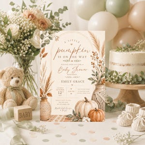 May include: A rectangular baby shower invitation card featuring a cream background with a botanical arch, pampas grass, pumpkins, and the text A little pumpkin is on the way, honoring Emily Grace, with event details for October 12th.